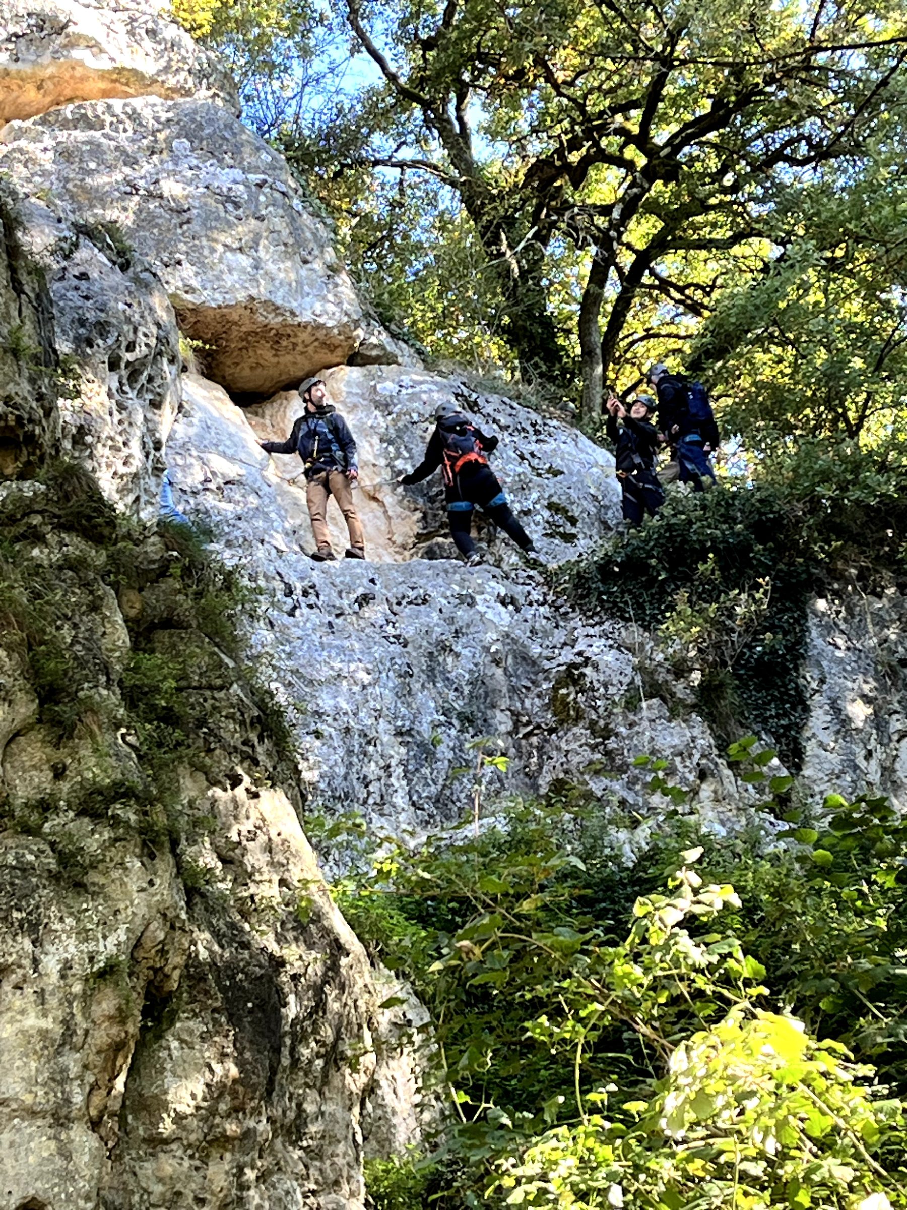 Une équipe progresse sur une paroi rocheuse en pleine nature